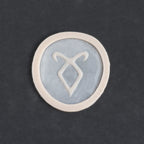 Angel Rune Scarification in vanilla shade on a black surface.