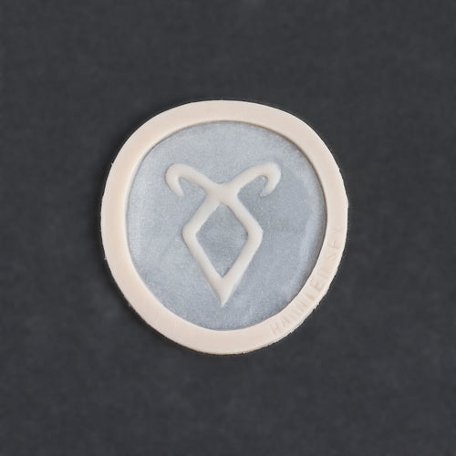 Angel Rune Scarification in vanilla shade on a black surface.