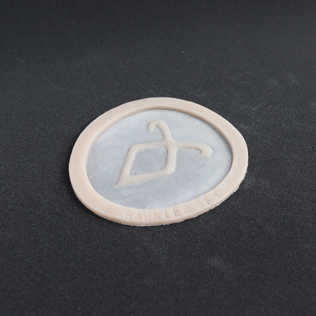 Angel Rune Scarification in vanilla shade at an angle on a black surface.