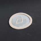 Angel Rune Scarification in vanilla shade at an angle on a black surface.