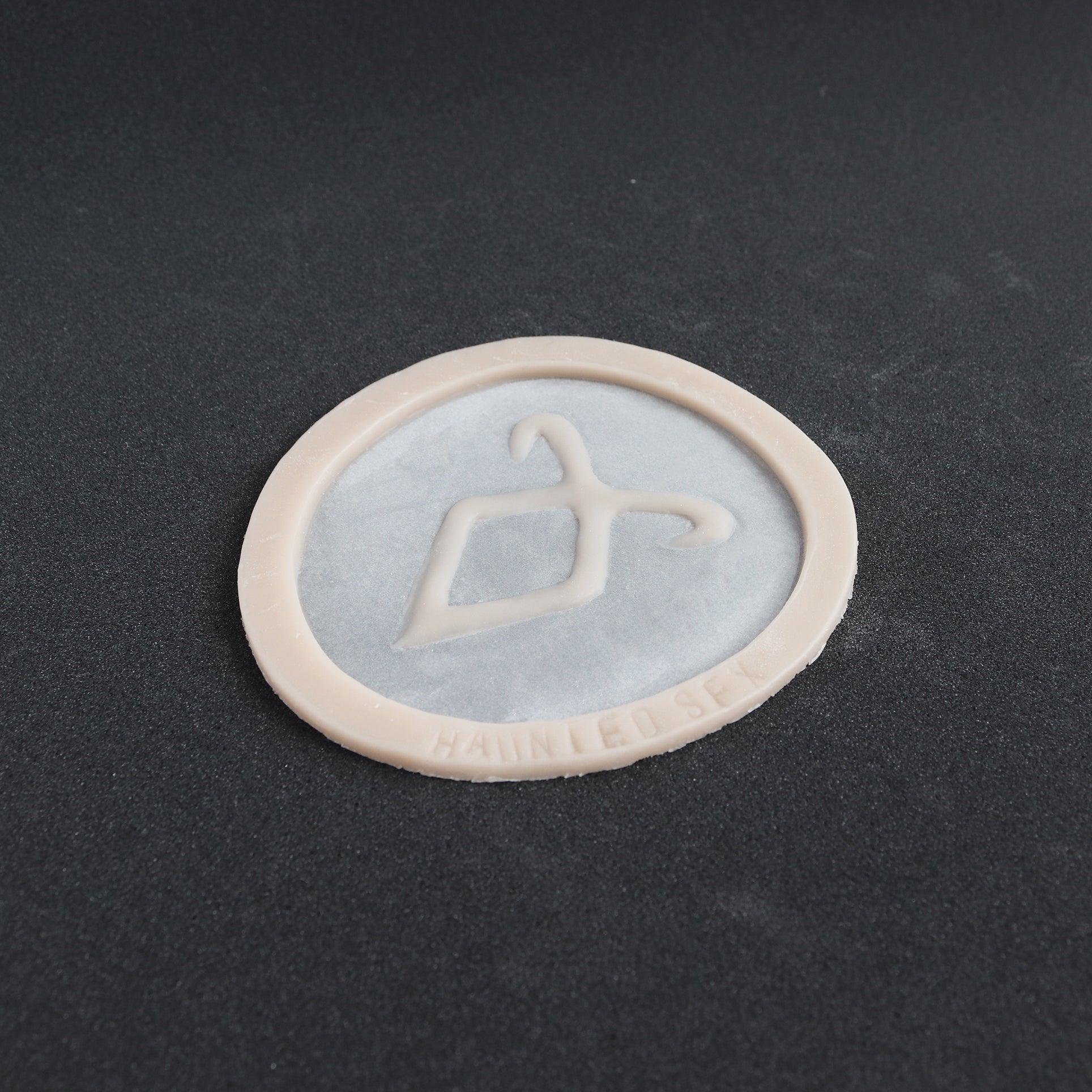 Angel Rune Scarification in vanilla shade at an angle on a black surface.