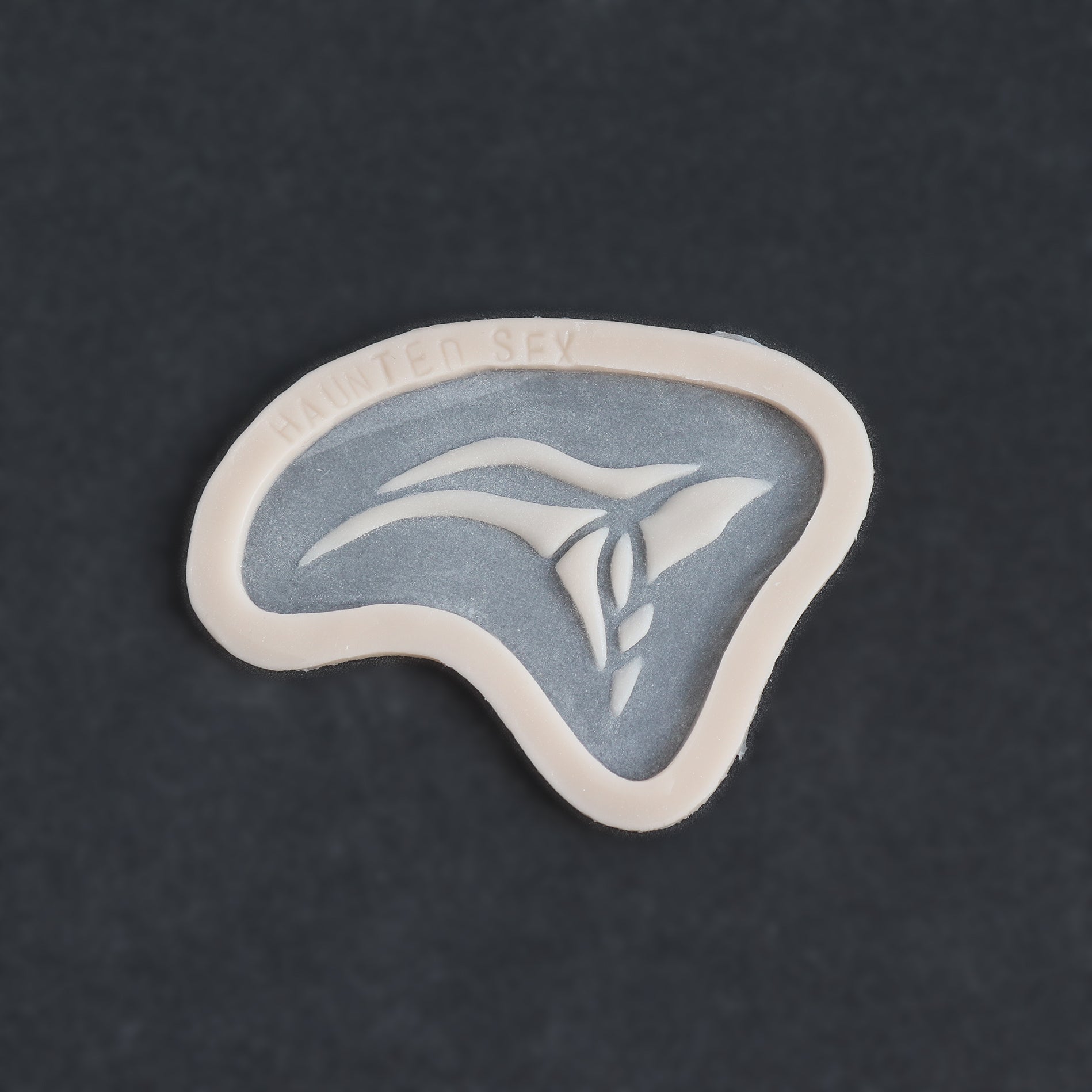 Anubis Mark - Silicone makeup prosthetic in vanilla shade on a black surface