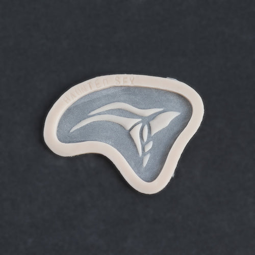 Anubis Mark - Silicone makeup prosthetic in vanilla shade on a black surface