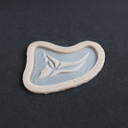 Anubis Mark - Silicone makeup prosthetic in vanilla shade on a black surface