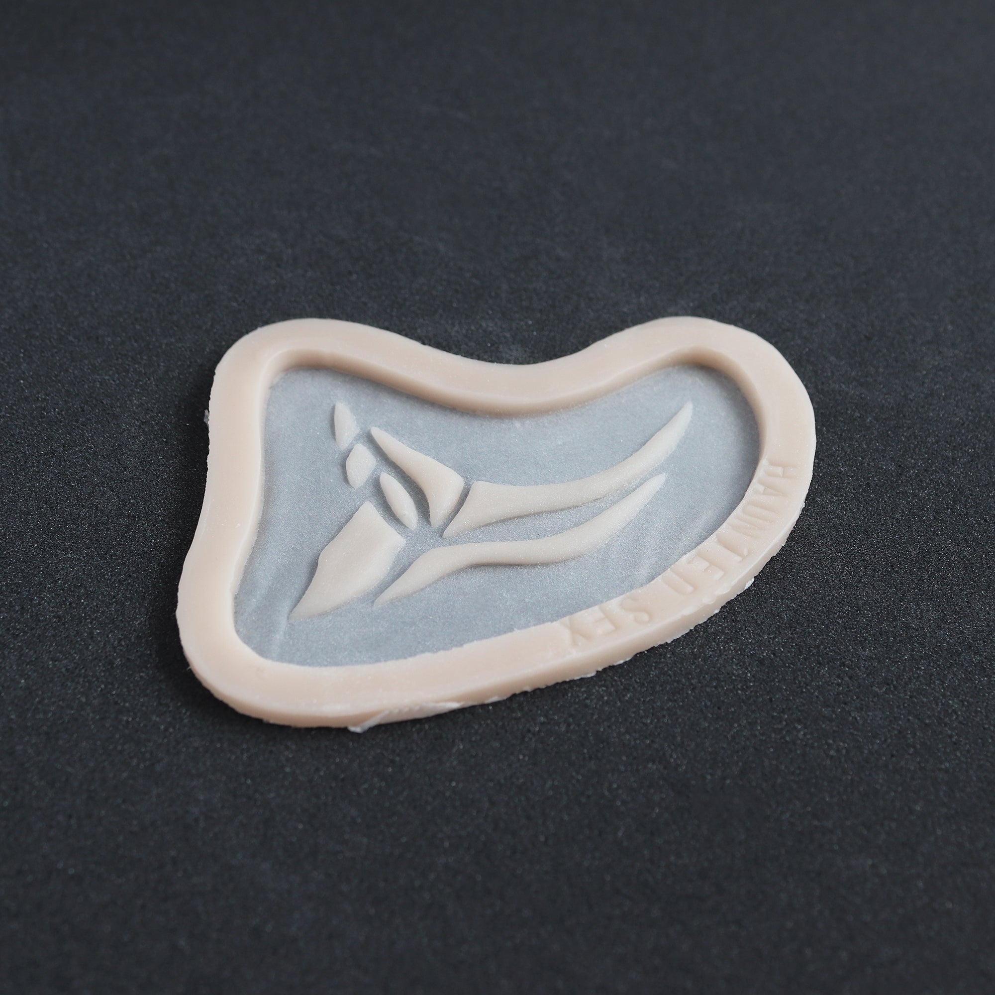 Anubis Mark - Silicone makeup prosthetic in vanilla shade on a black surface