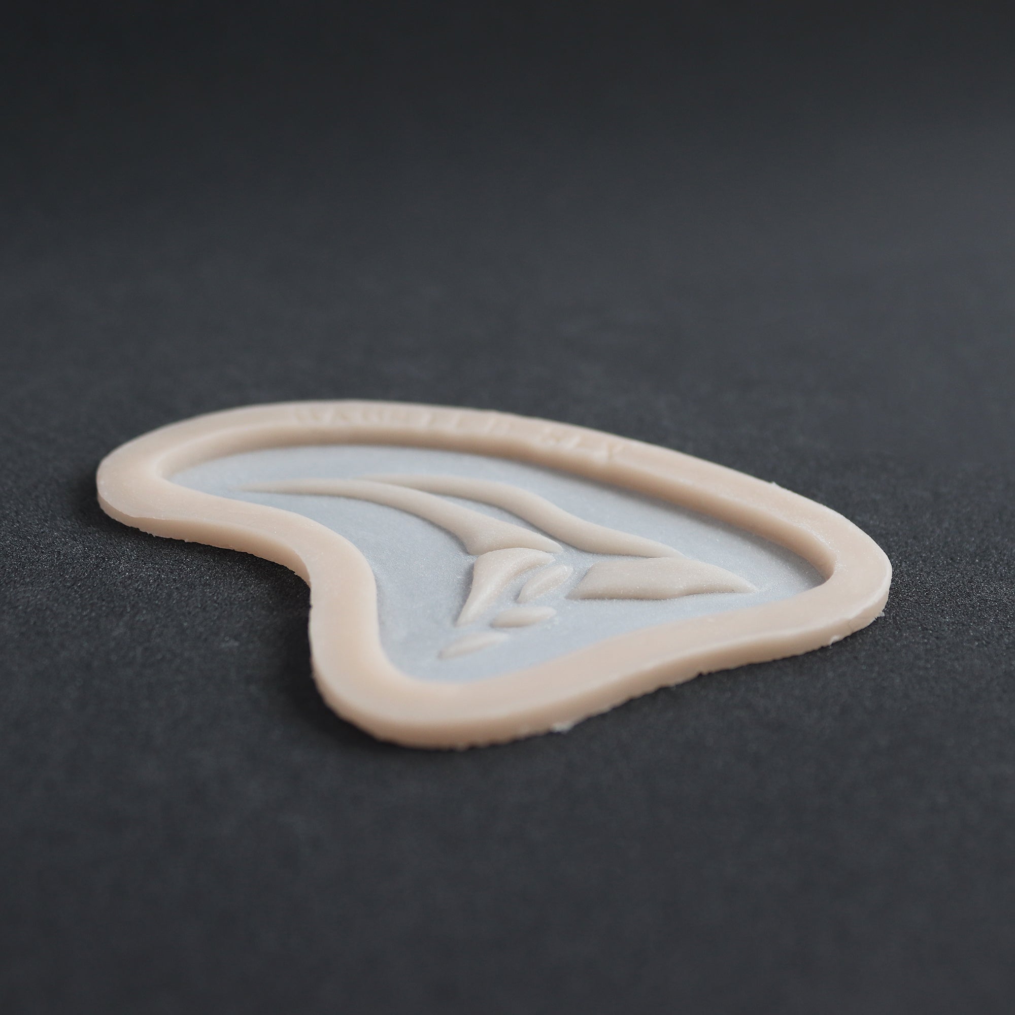 Anubis Mark - Silicone makeup prosthetic in vanilla shade on a black surface