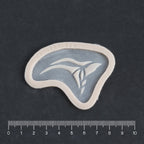 Anubis Mark - Silicone makeup prosthetic in vanilla shade on a black surface with a ruler