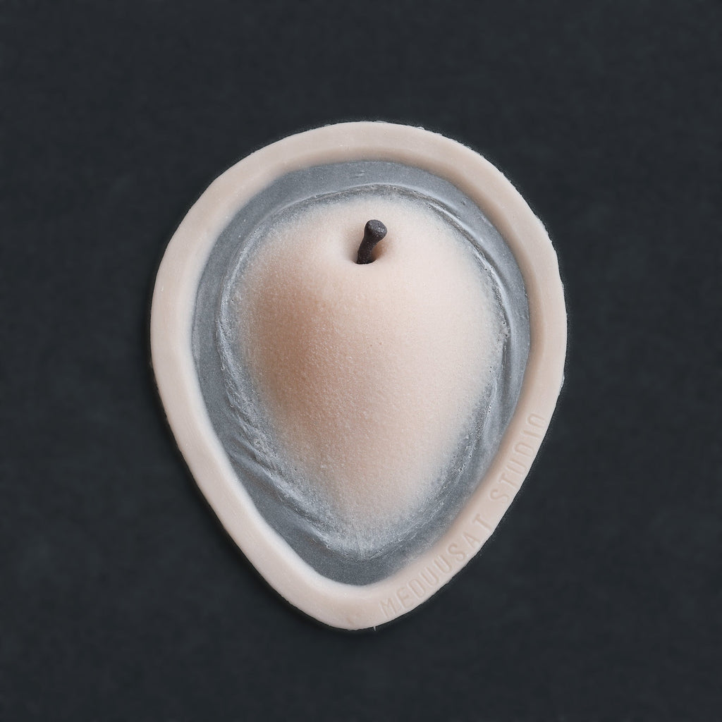 Apple Cheek prosthetic in vanilla shade on a black surface.