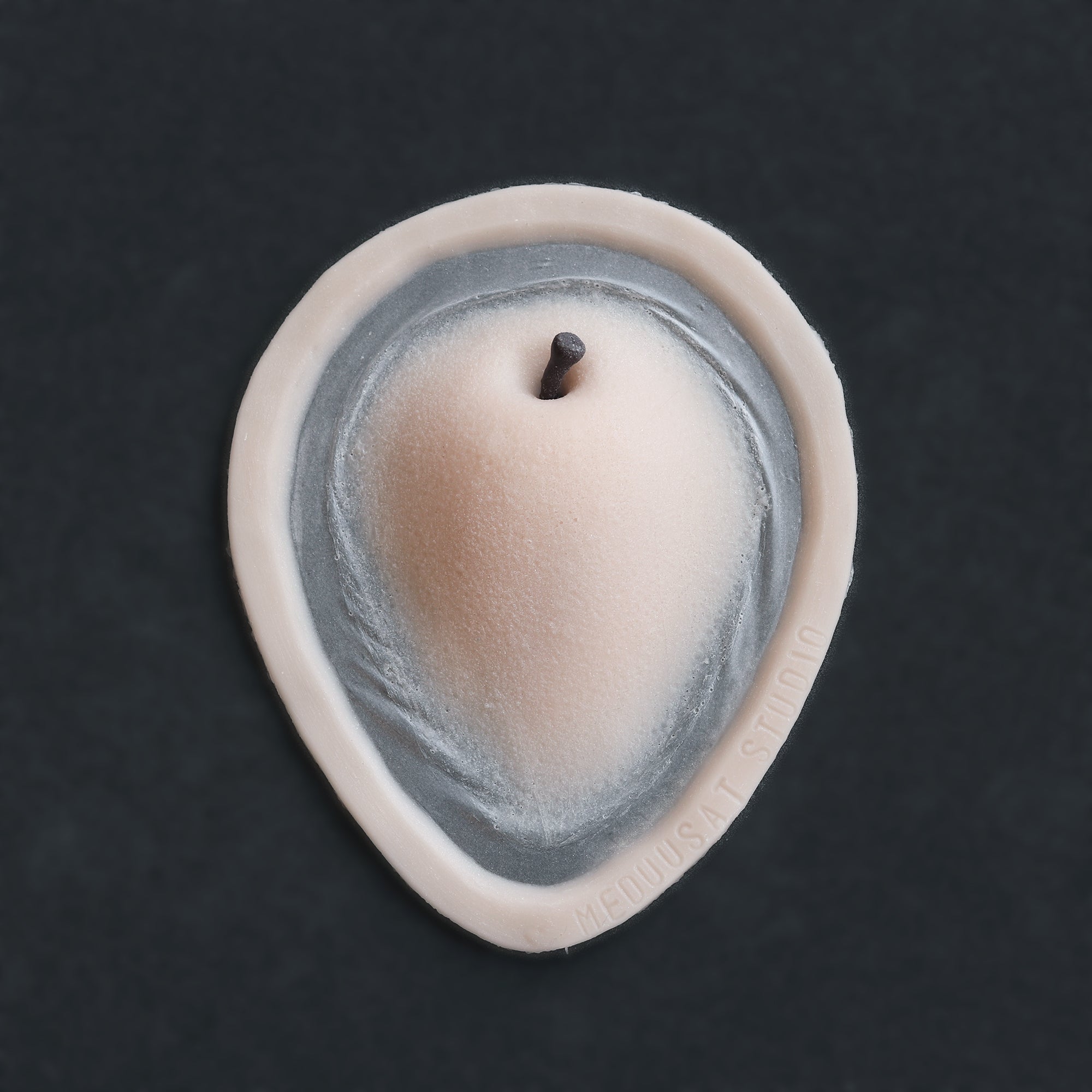 Apple Cheek prosthetic in vanilla shade on a black surface.