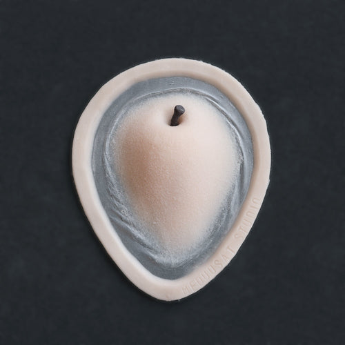 Apple Cheek prosthetic in vanilla shade on a black surface.