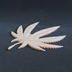 Cannabis Pasties / Nipple Patches (Pair) - Silicone makeup prosthetic in vanilla shade on a black surface at a steep angle