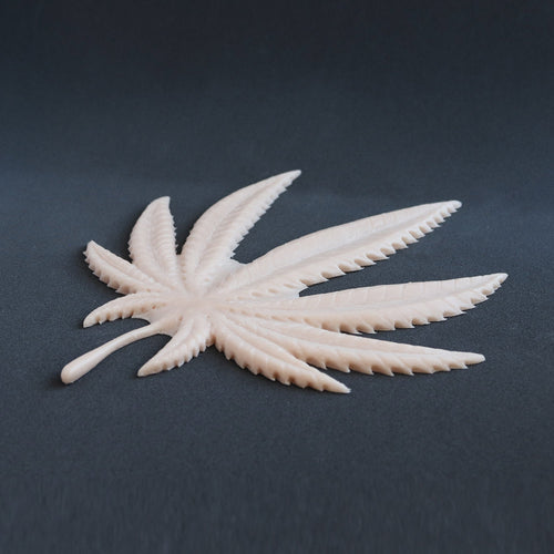 Cannabis Pasties / Nipple Patches (Pair) - Silicone makeup prosthetic in vanilla shade on a black surface at a steep angle