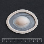 Closed Third Eye - Silicone makeup prosthetic in vanilla shade on a black surface with a ruler