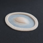Closed Third Eye - Silicone makeup prosthetic in vanilla shade on a black surface at an angle