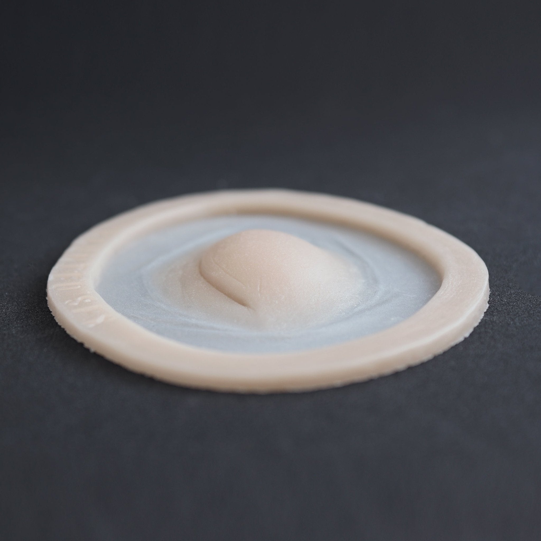 Closed Third Eye - Silicone makeup prosthetic in vanilla shade on a black surface at a steep angle