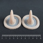 Crooked Horns (Pair) - Silicone makeup prosthetic in vanilla shade on a black surface with a ruler