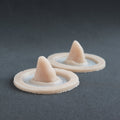 Crooked Horns (Pair) - Silicone makeup prosthetic in vanilla shade on a black surface