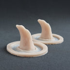 Crooked Horns (Pair) - Silicone makeup prosthetic in vanilla shade on a black surface