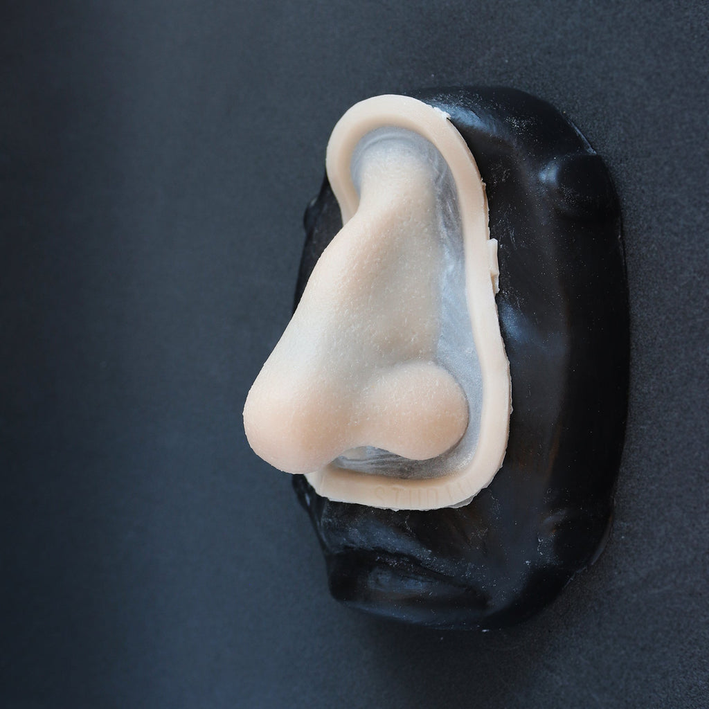 Crooked Nose - Silicone makeup prosthetic in vanilla shade on a black surface