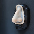Crooked Nose - Silicone makeup prosthetic in vanilla shade on a black surface
