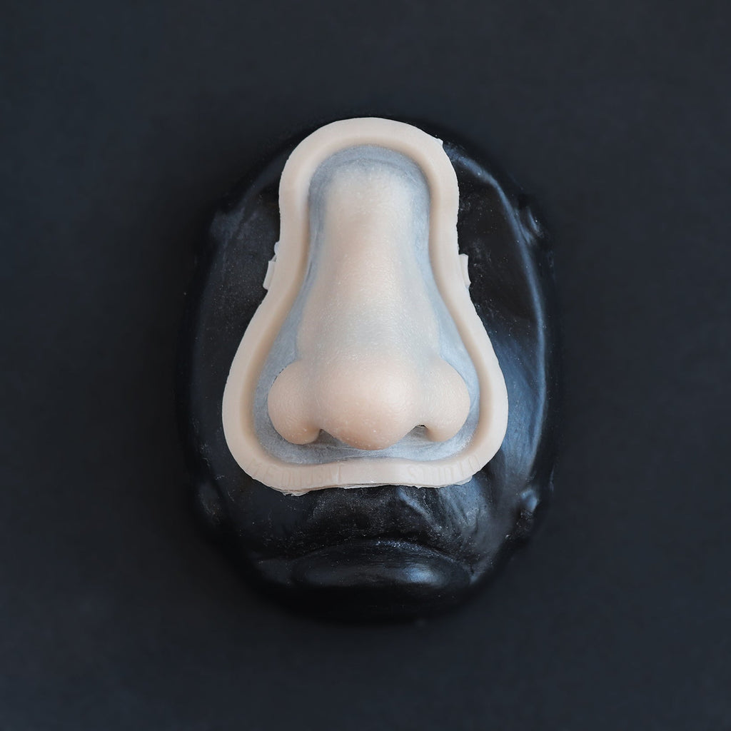 Crooked Nose - Silicone makeup prosthetic in vanilla shade on a black surface