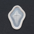 Cross Carving - Silicone makeup prosthetic in vanilla shade on a black surface