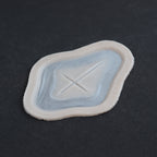 Cross Carving - Silicone makeup prosthetic in vanilla shade on a black surface