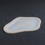 Cross Carving - Silicone makeup prosthetic in vanilla shade on a black surface