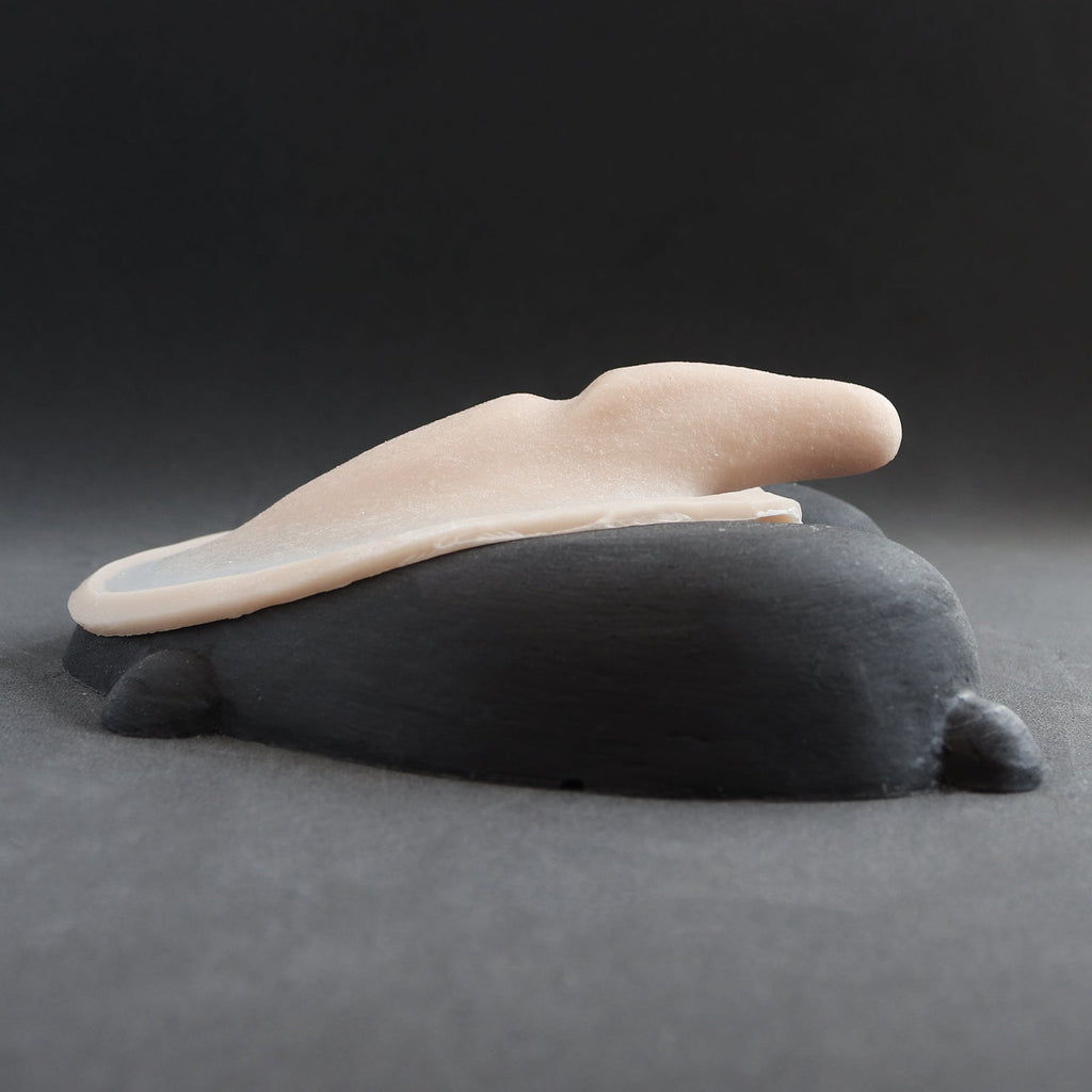 Demon Tail - Silicone makeup prosthetic in vanilla shade on a black surface