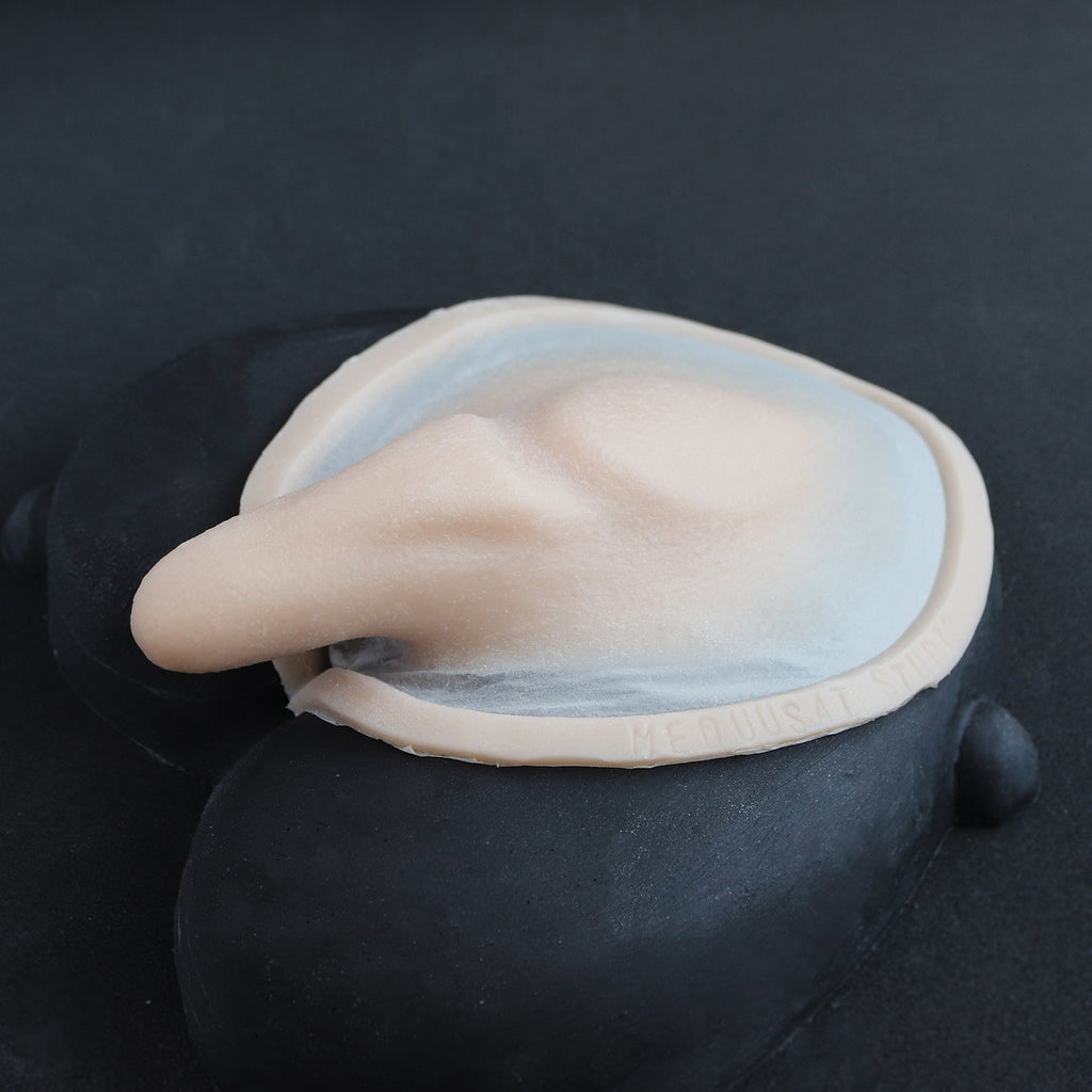 Demon Tail - Silicone makeup prosthetic in vanilla shade on a black surface