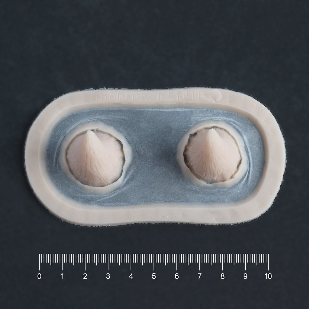 Devil Horns - Silicone makeup prosthetic in vanilla shade on a black surface with a ruler