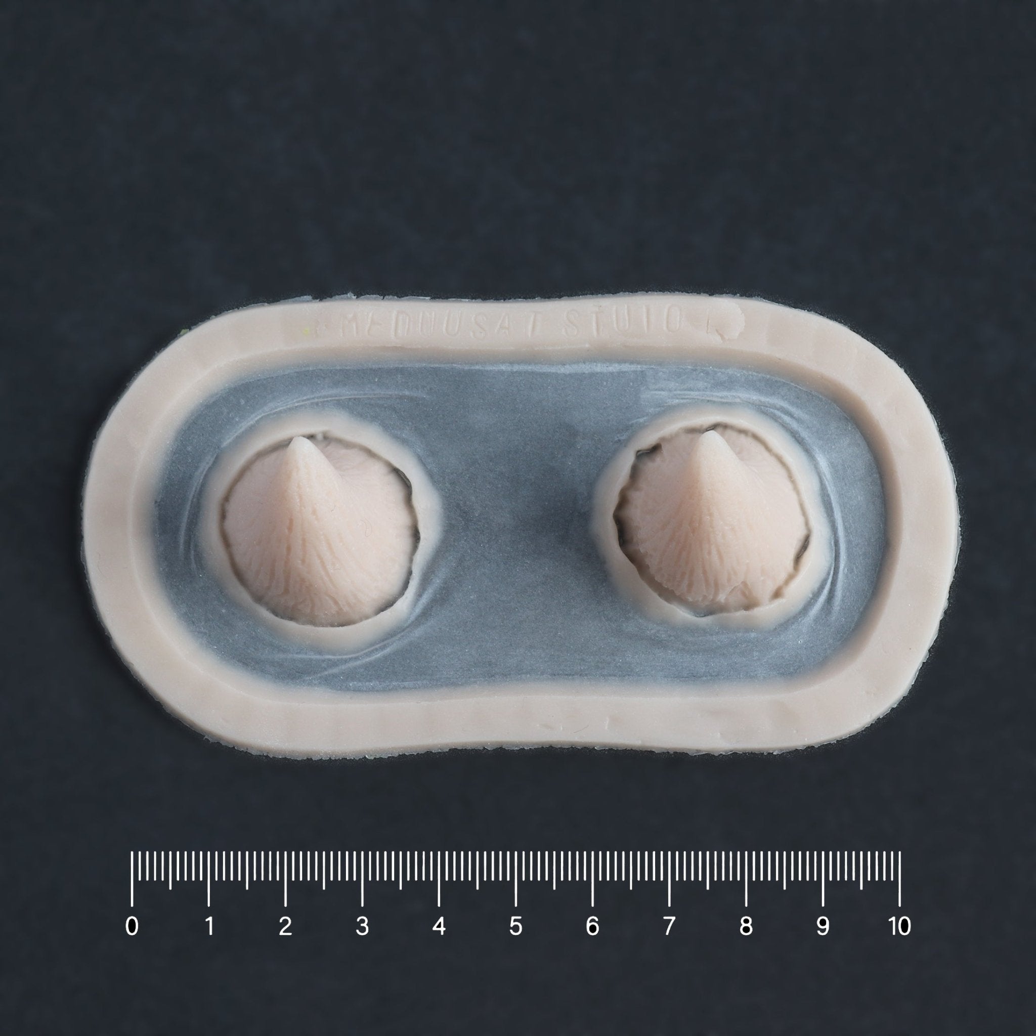 Devil Horns - Silicone makeup prosthetic in vanilla shade on a black surface with a ruler