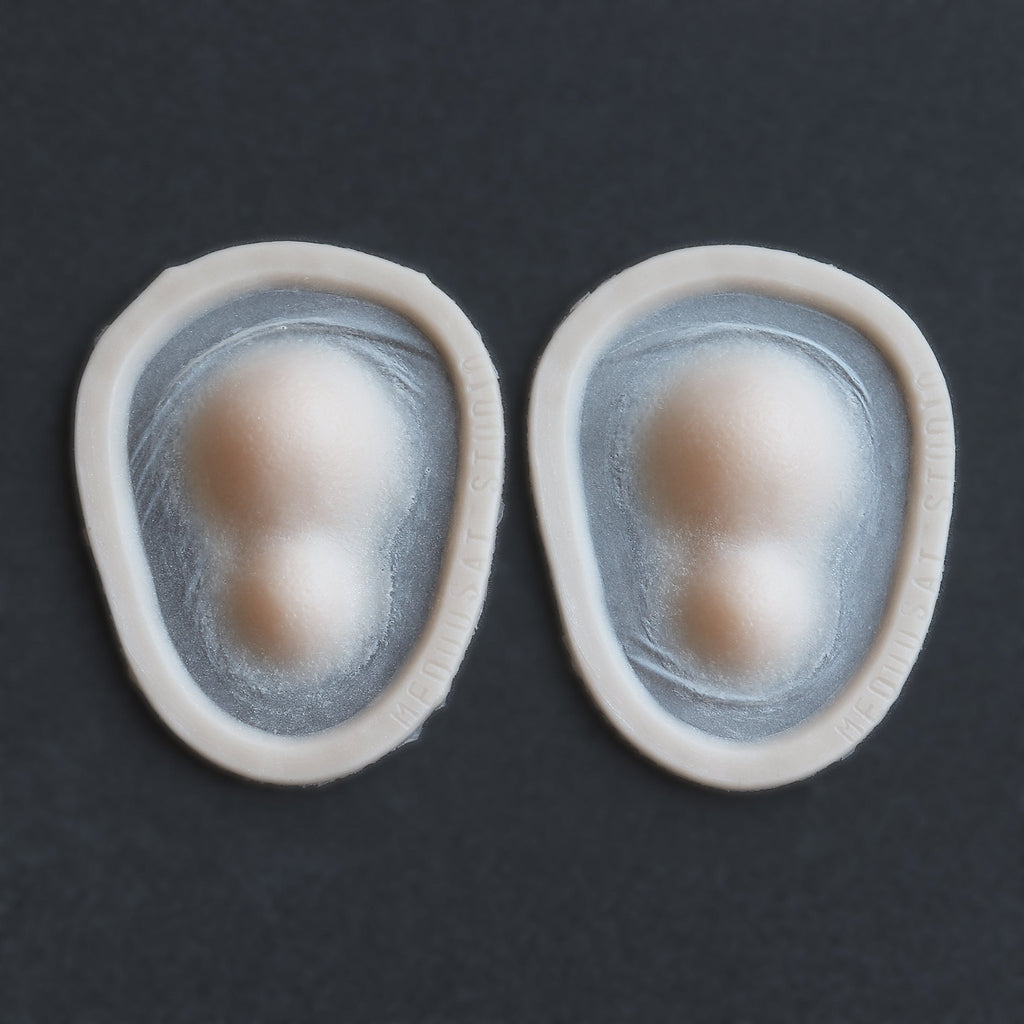 Double Subdermal Horns (Pair) - Silicone makeup prosthetic in vanilla shade on a black surface