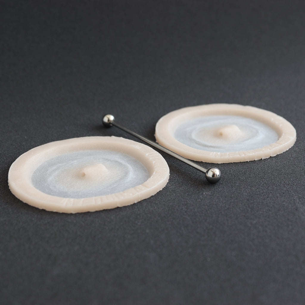 Double Surface Piercing - Silicone makeup prosthetic in vanilla shade on a black surface