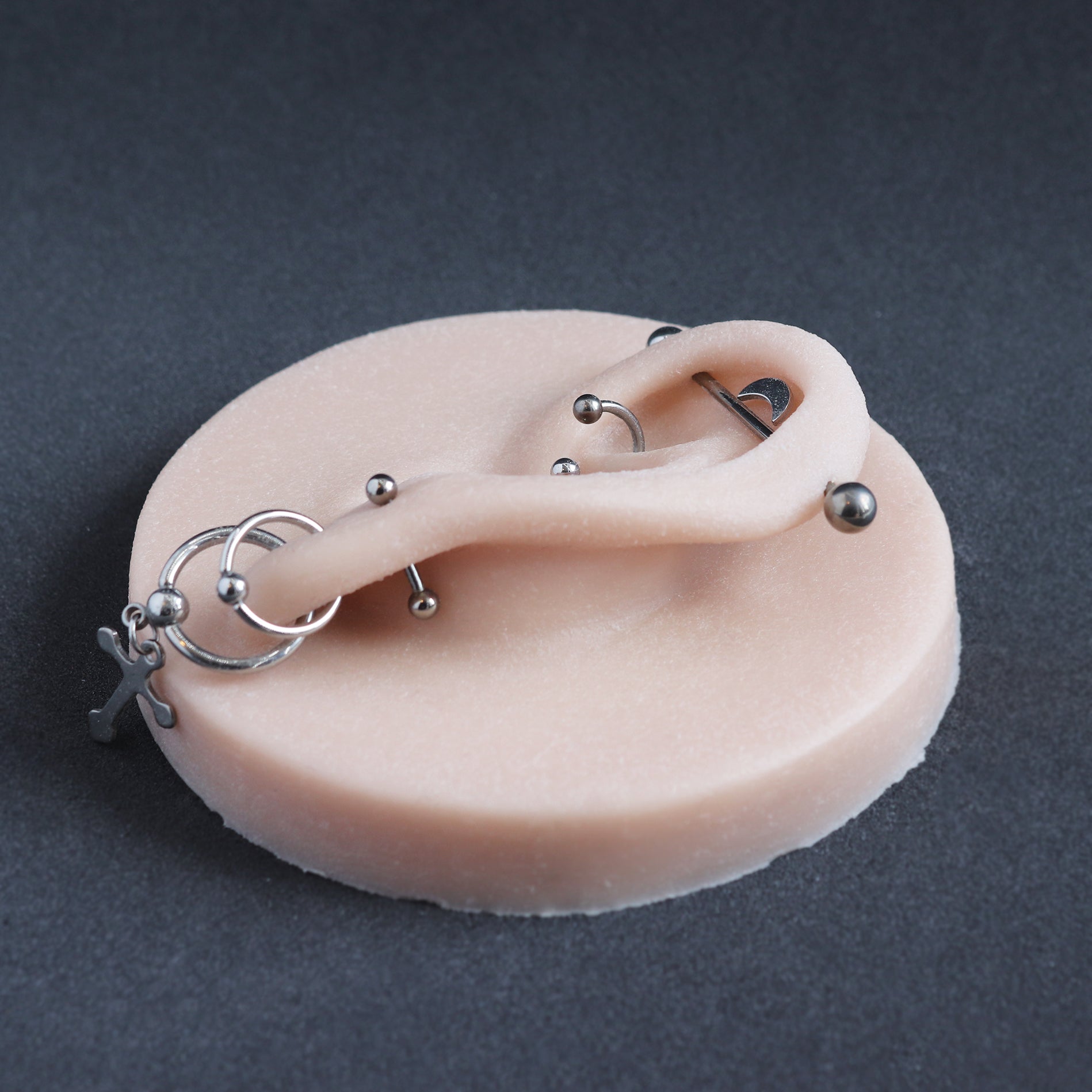 Ear Jewellery Display in vanilla shade on a black surface