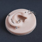 Ear Jewellery Display in vanilla shade on a black surface