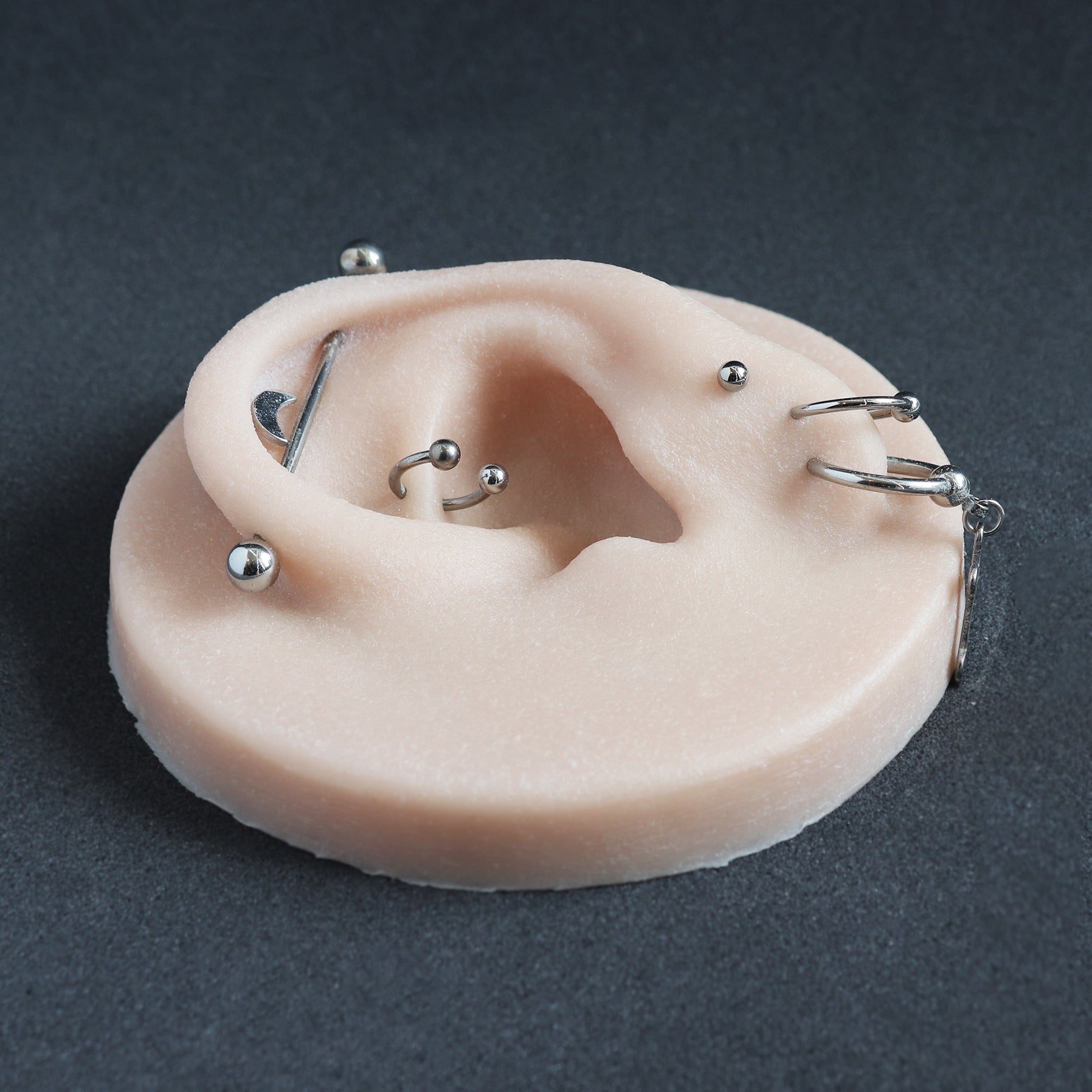 Ear Jewellery Display in vanilla shade on a black surface