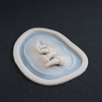 Facial Fangs 2.0 - Silicone makeup prosthetic in vanilla shade on a black surface