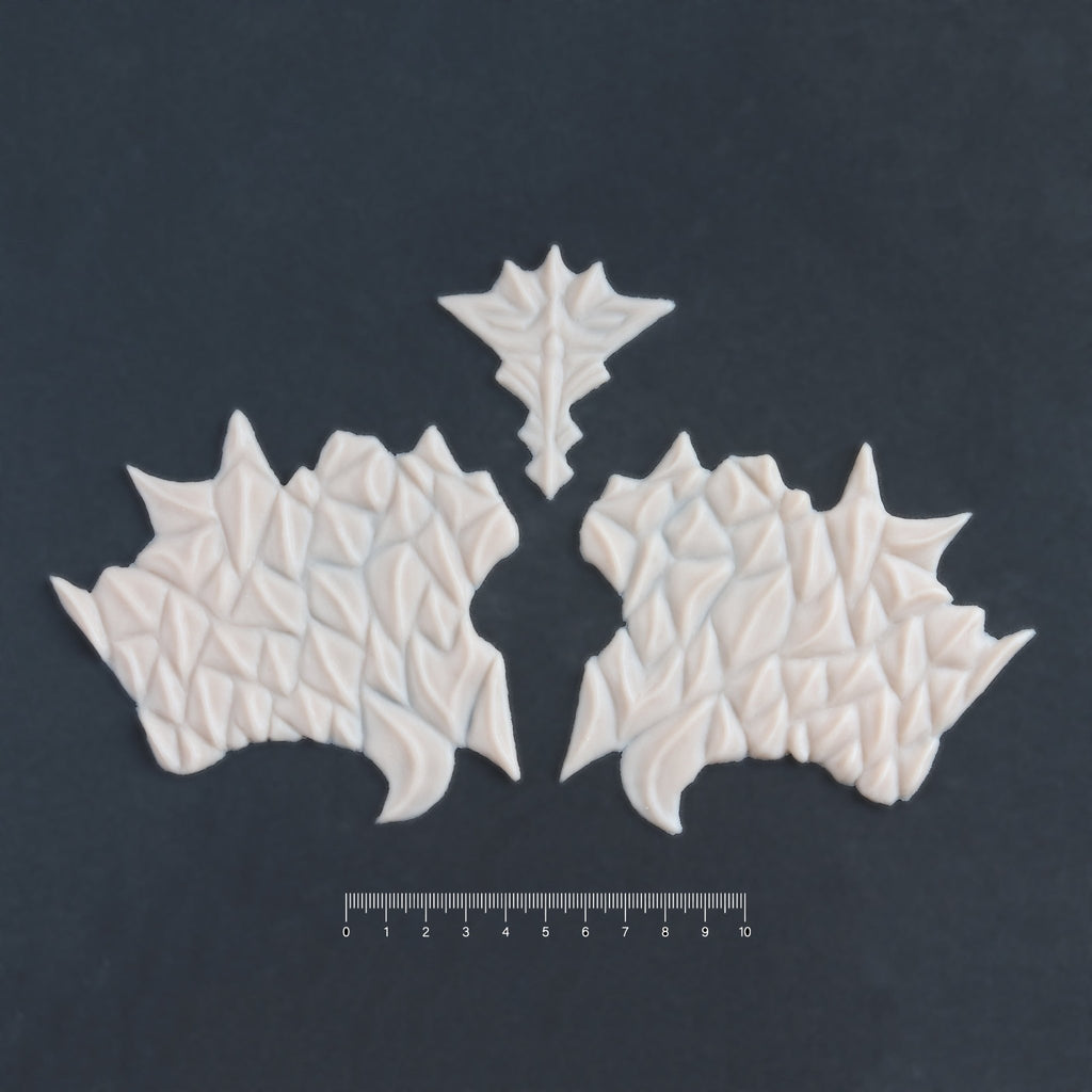 Facial Scales 2.0 - Silicone makeup prosthetic in vanilla shade on a black surface with a ruler