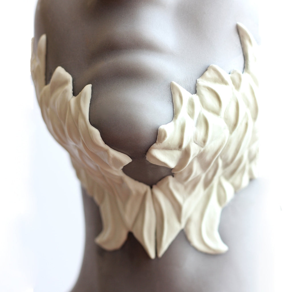 Mannequin wearing white facial scale prosthetics