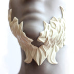 Mannequin wearing white facial scale prosthetics