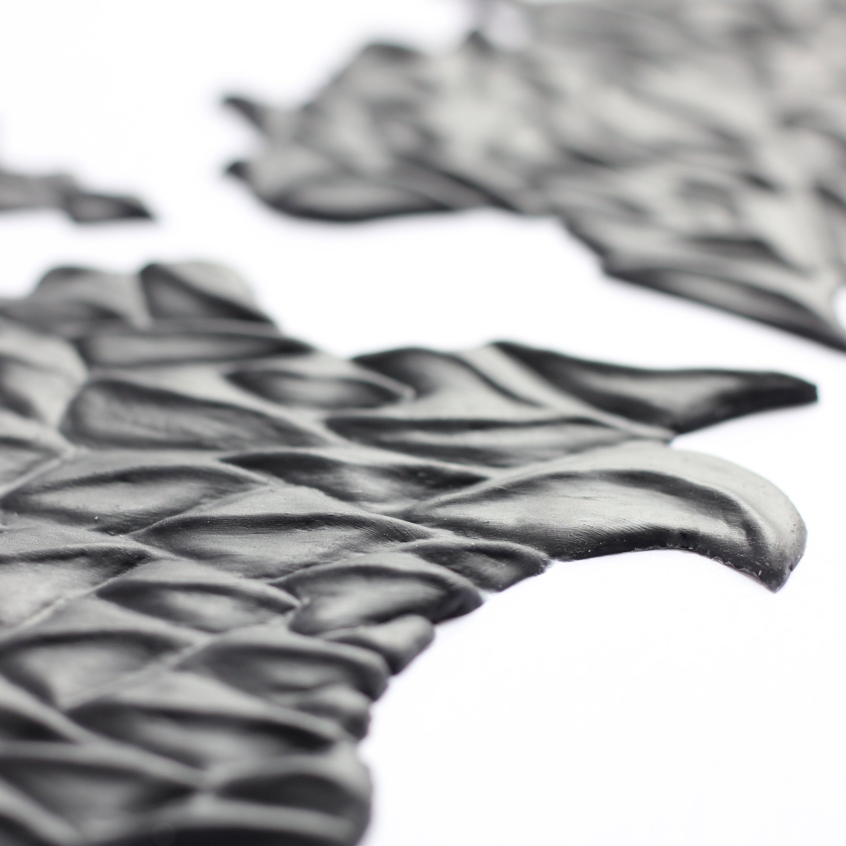 Facial Scales 2.0 - Silicone makeup prosthetic in black on a white surface