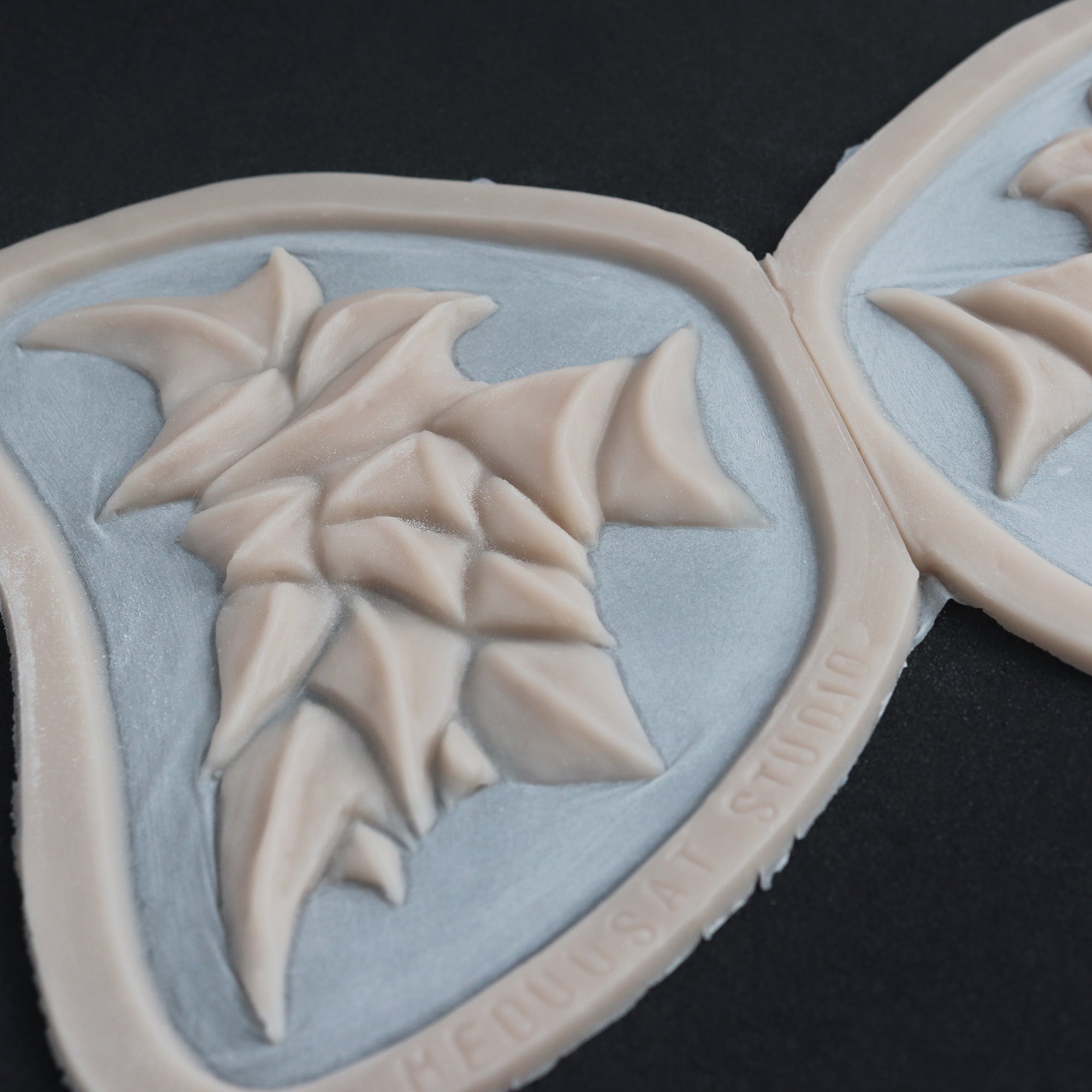 Facial Scales - Silicone makeup prosthetic in vanilla shade on a black surface