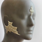 Mannequin wearing white facial scale prosthetics