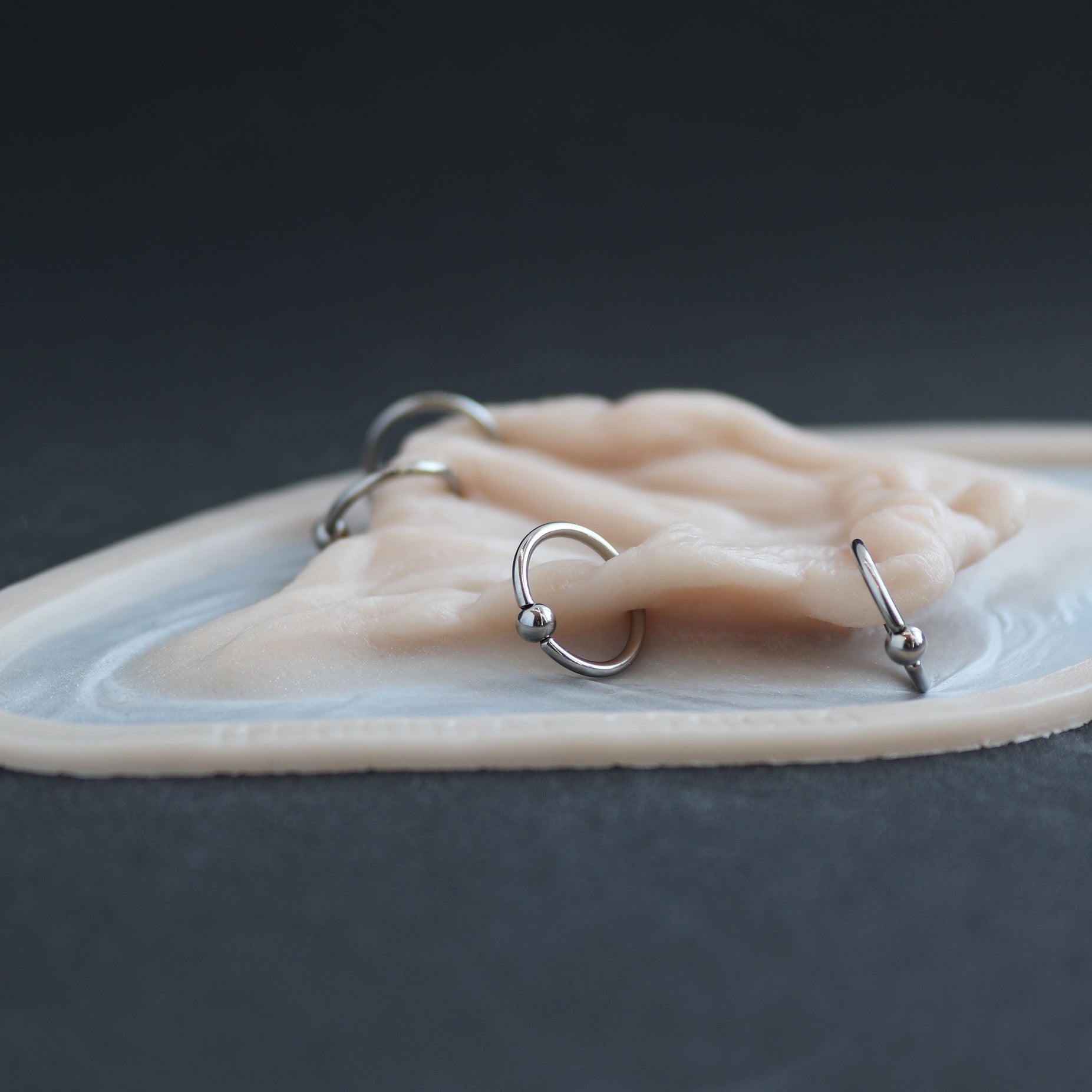 Flower Choker - Silicone makeup prosthetic in vanilla shade on a black surface