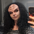 Woman with black bushy hair wearing forehead ridges in vanilla shade