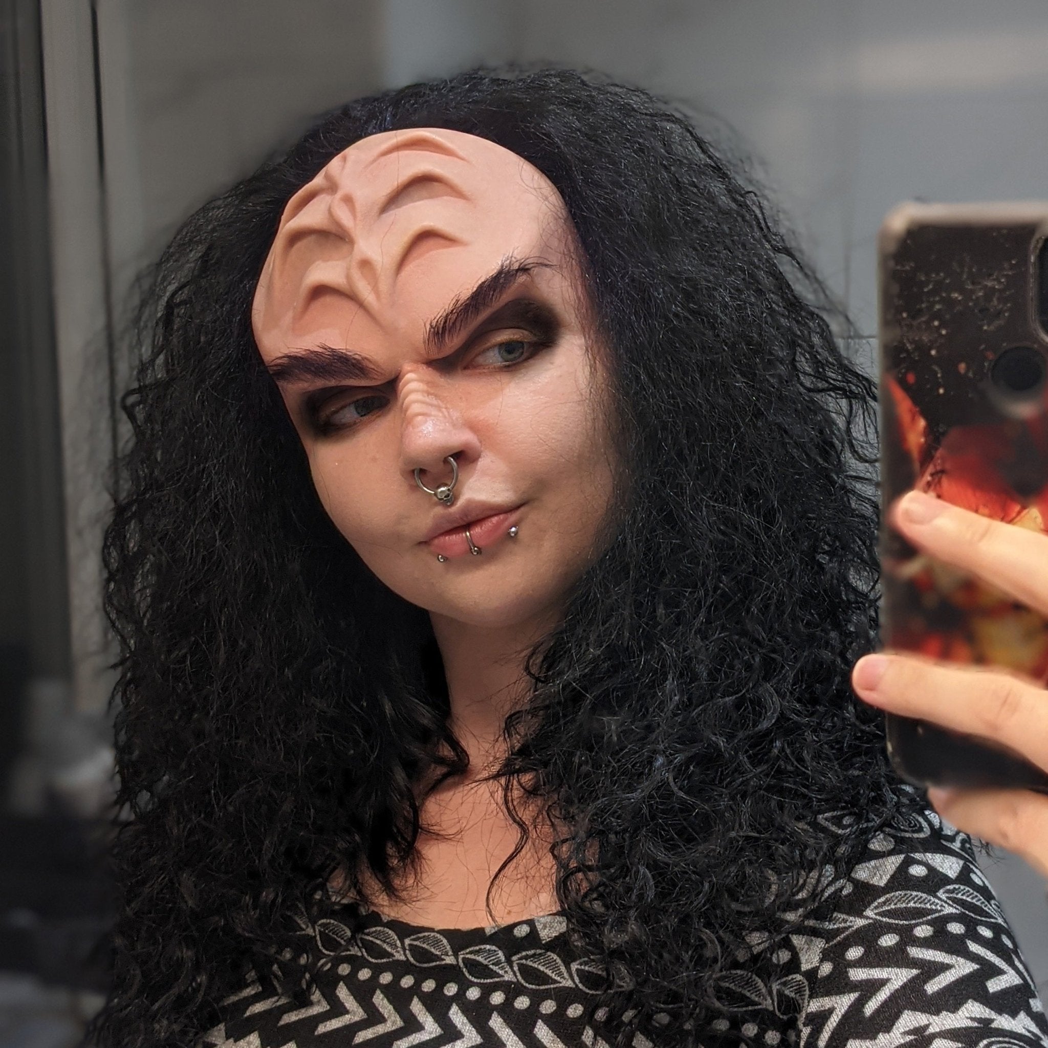 Woman with black bushy hair wearing forehead ridges in vanilla shade