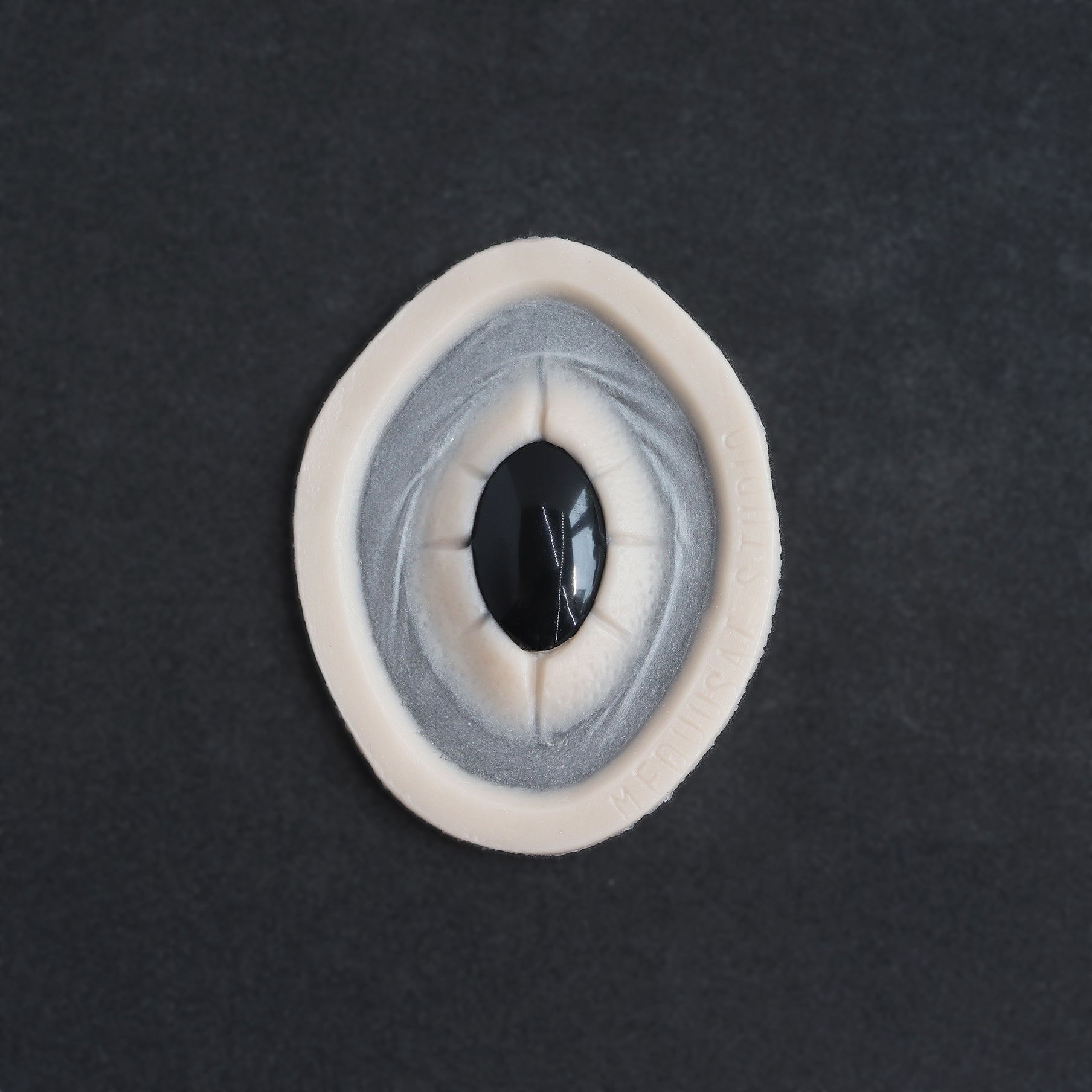 Gem - Silicone makeup prosthetic in vanilla shade on a black surface