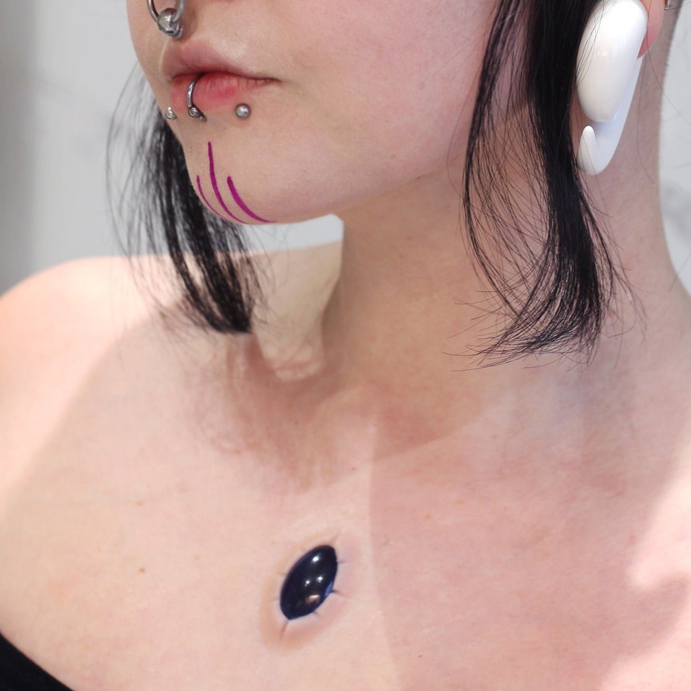 Woman with a gem prosthetic on her chest