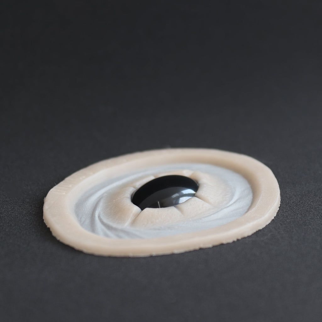 Gem - Silicone makeup prosthetic in vanilla shade on a black surface